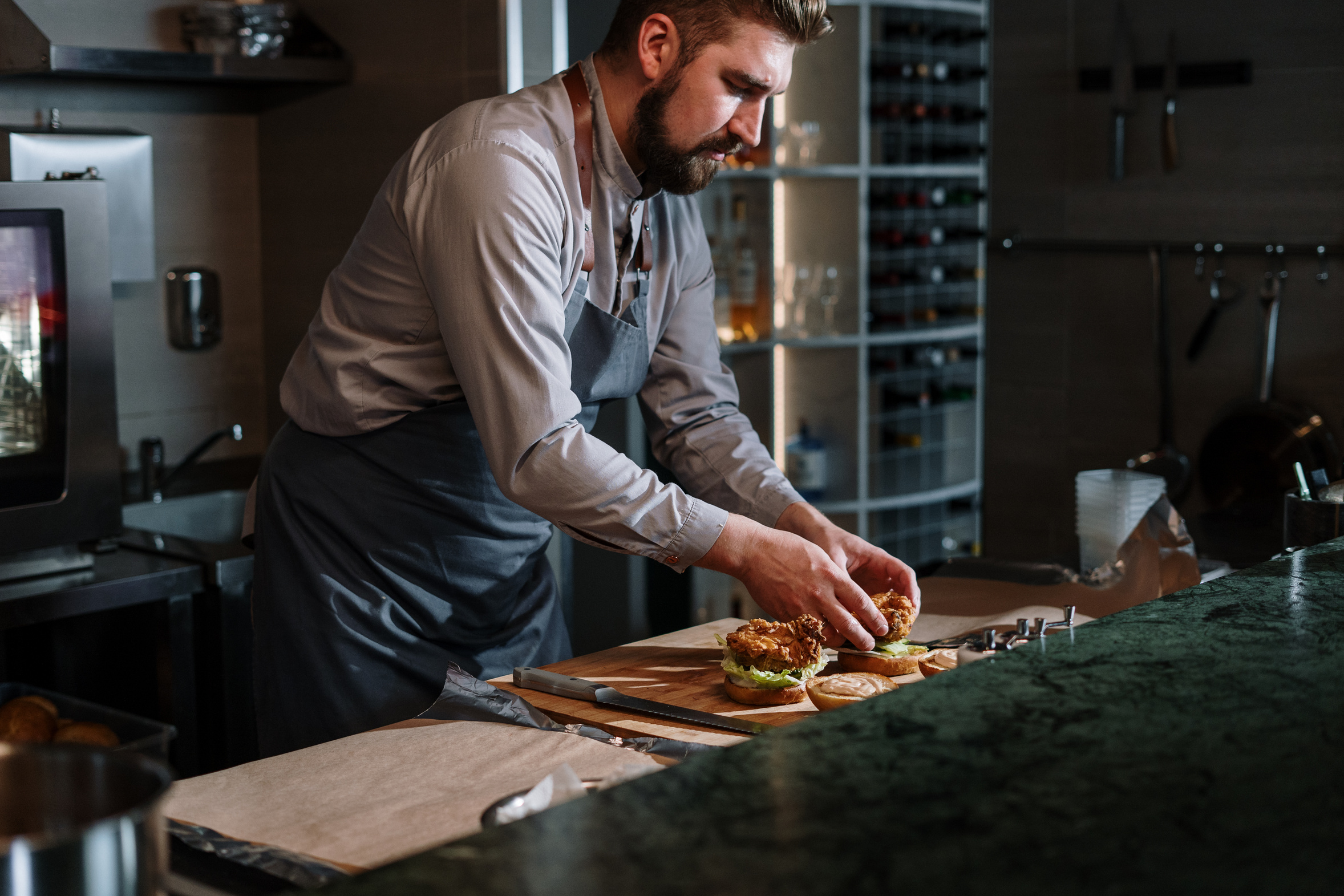 Man in White Dress Shirt Slicing Pizza